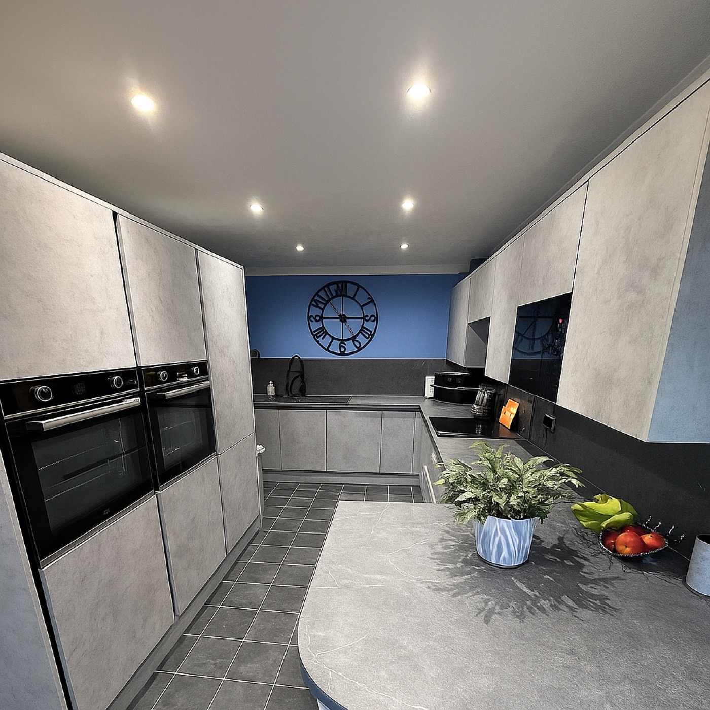 Grey concrete-effect handleless kitchen fitted for Alison